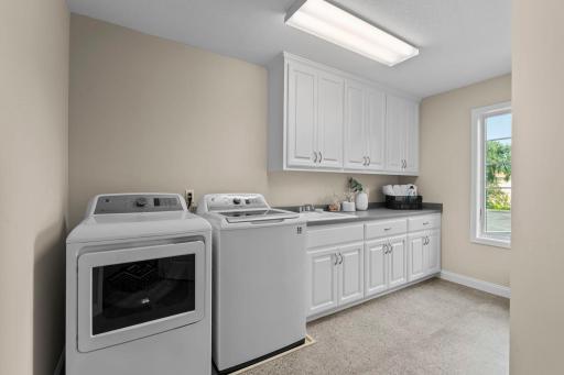 Laundry room serving the upper level, with cabinetry, sink, and countertops.