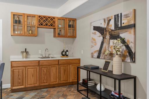Wet bar area complete with stunning cabinerty and tile flooring.