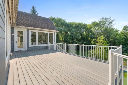 Spacious back yard deck with access to the pool, and main level sun room.