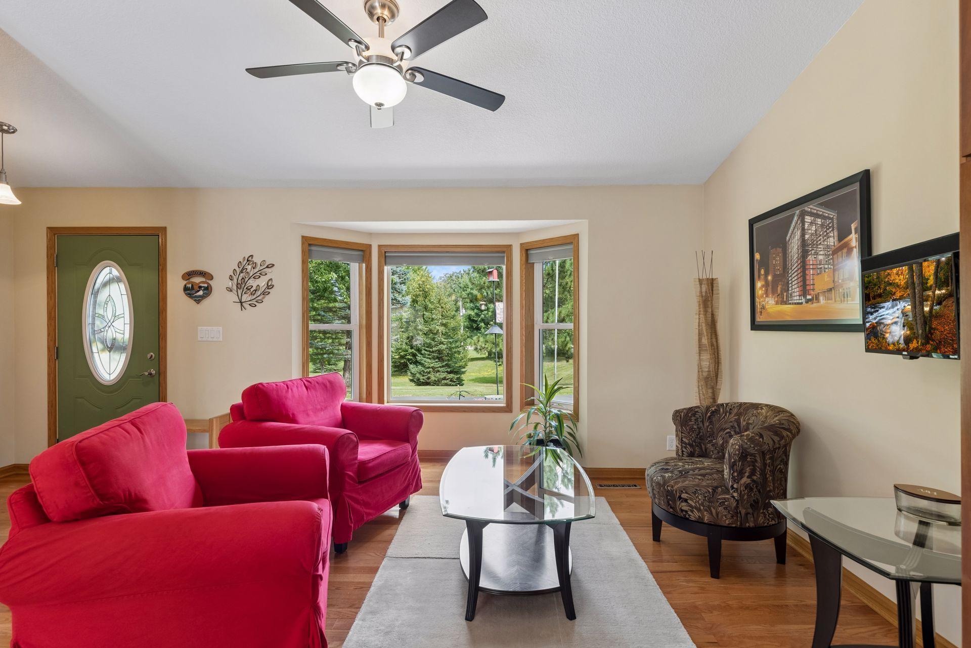 The front foyer, complete with coat closet, flows directly into the spacious living room, where hardwood flooring, a beautiful bay window and a ceiling fan with light create a comfortable gathering space.
