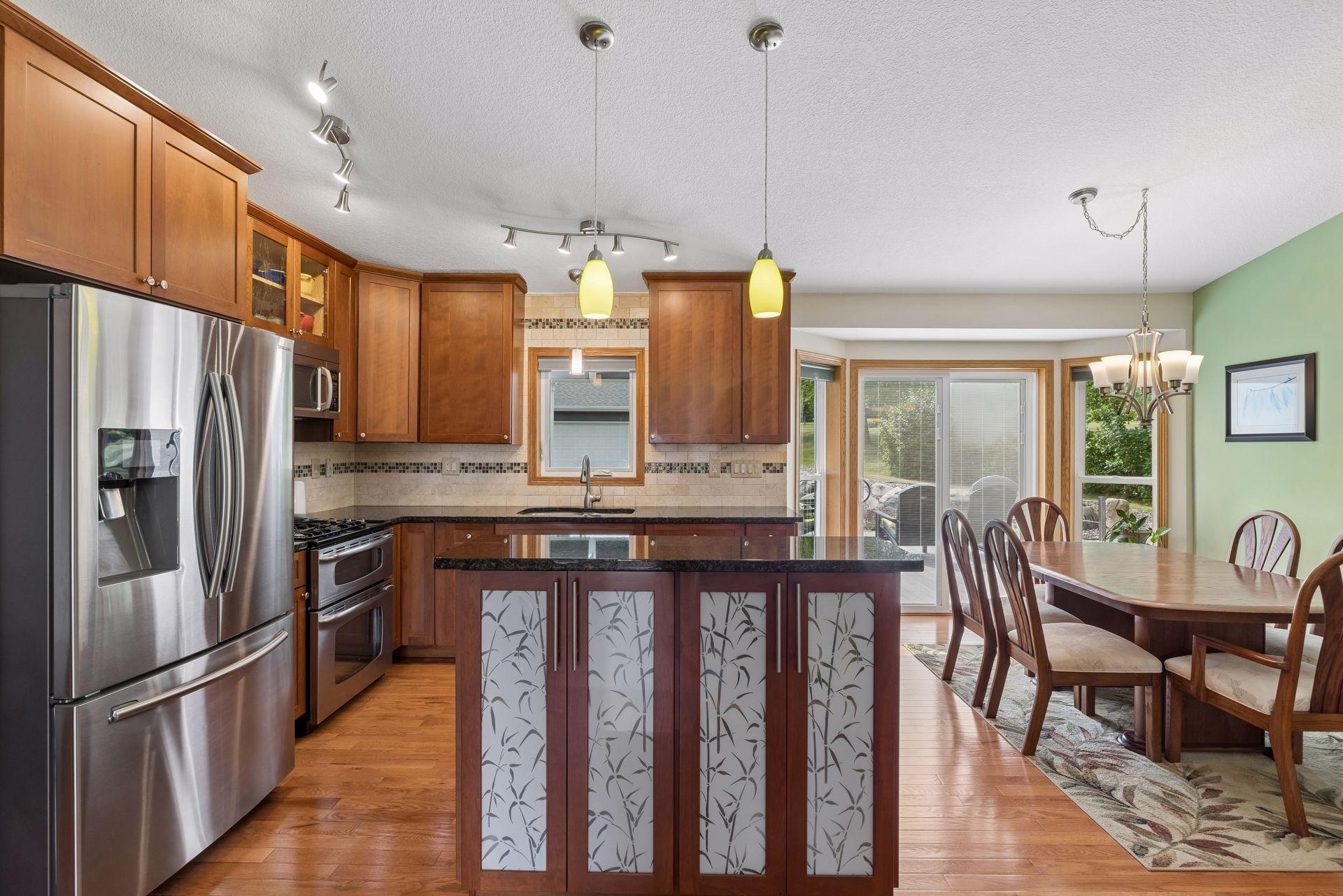Gather in the kitchen where hardwood floors continue throughout, while track and pendant lighting illuminate the island and casual dining space.