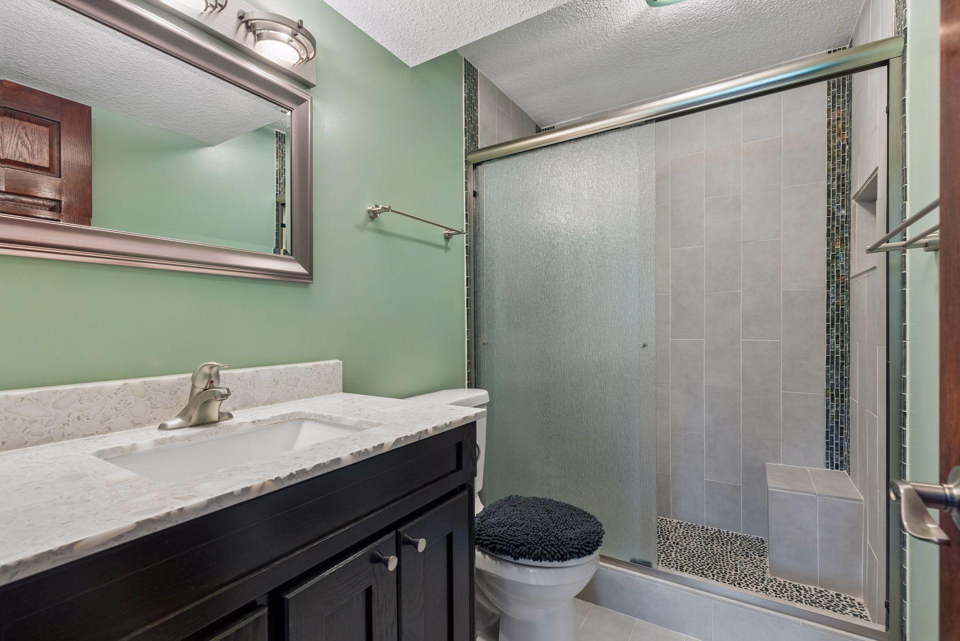 The lower level bathroom offers everyday functionality with tile flooring, a vanity sink, and a convenient shower.