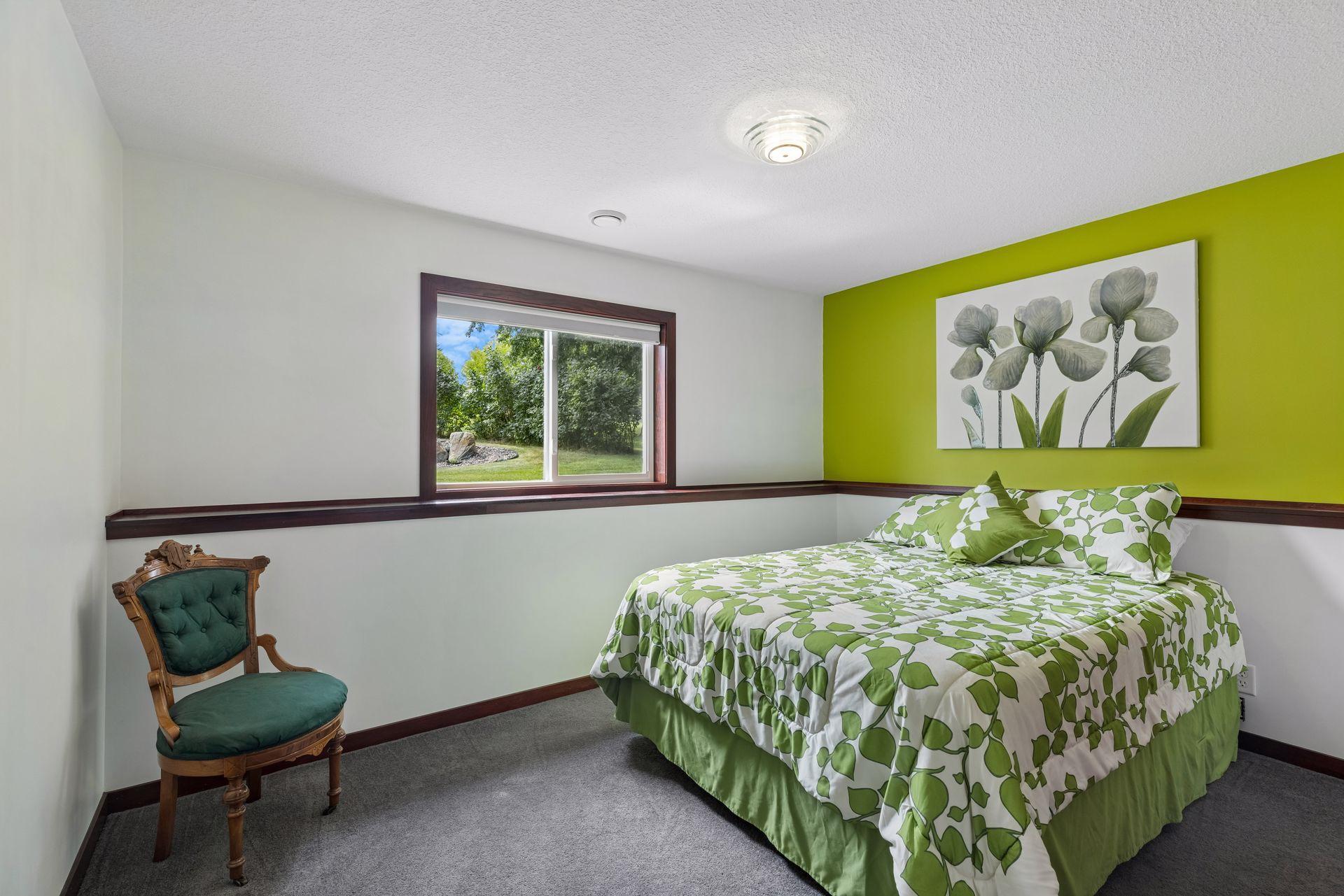 The lower-level bedroom provides a comfortable space with carpet flooring, double window, and overhead lighting.