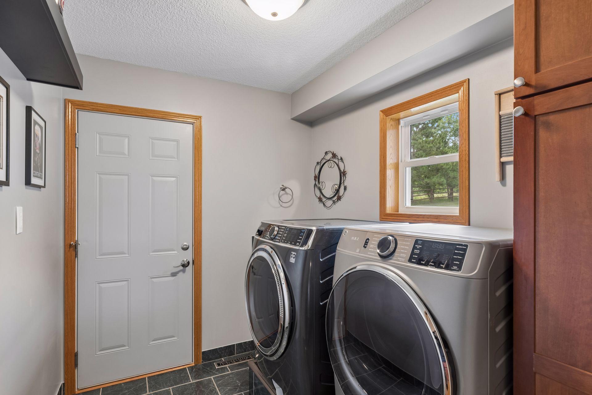 The main floor laundry room provides excellent functionality with tile flooring, a utility sink, abundant storage, and direct garage access.