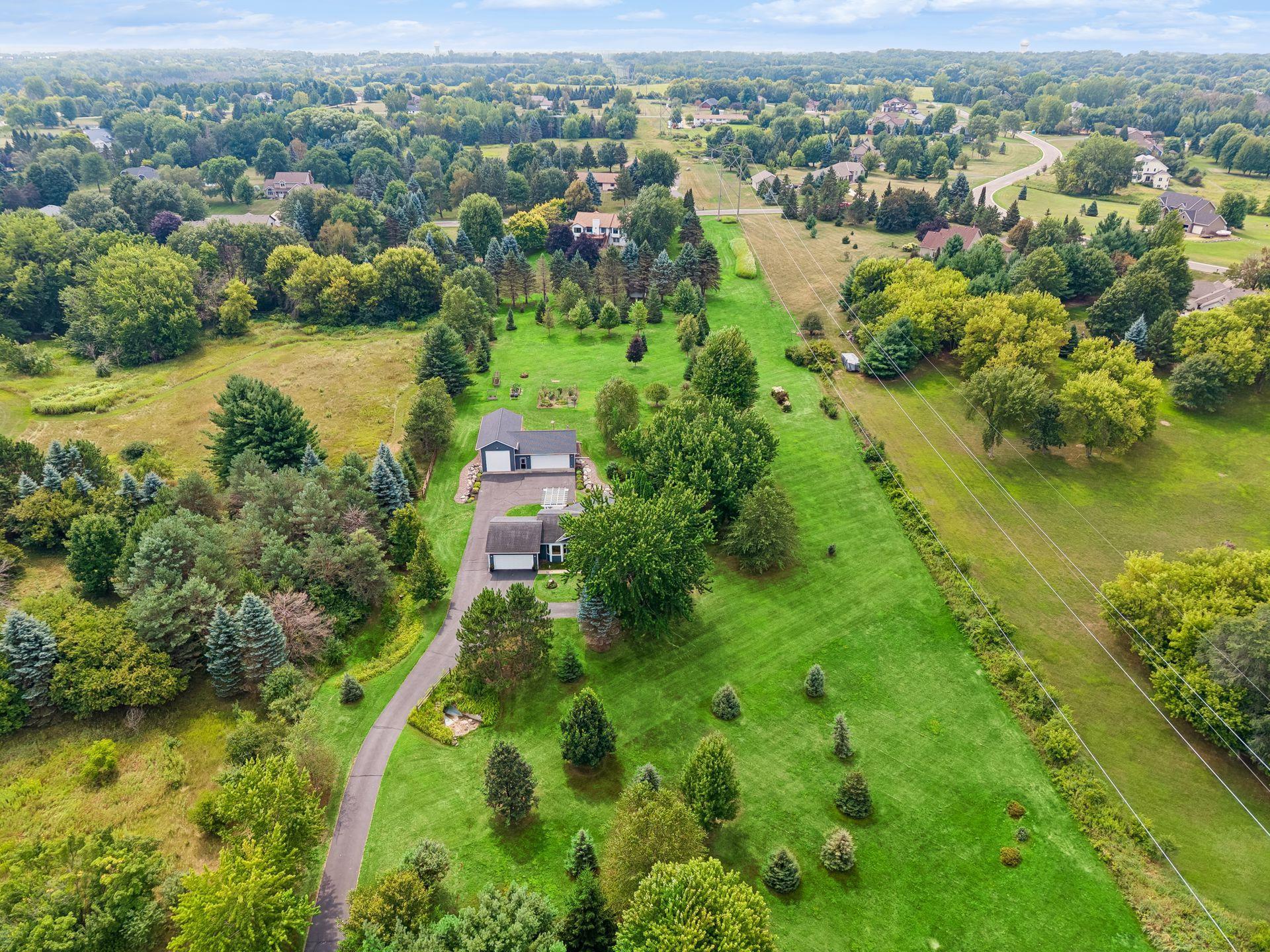Aerial photo showcasing the beautiful 2.88 acres! This photo is from the front of the yard to the back (the tall pine trees just before the white house).