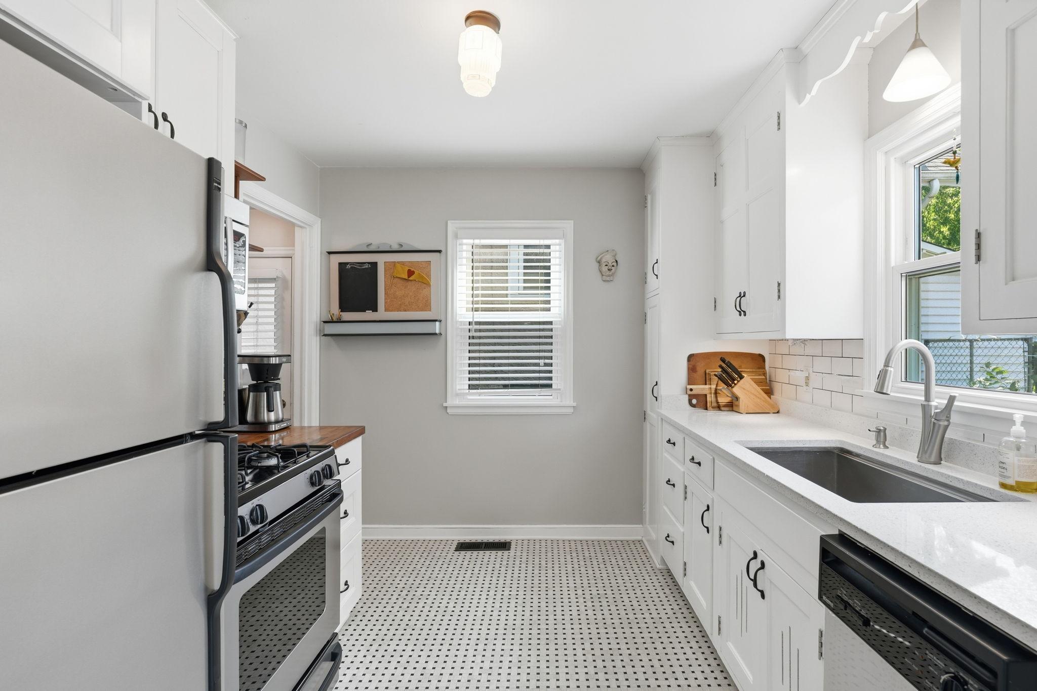 Spacious galley kitchen with stainless steel appliances is light and bright.