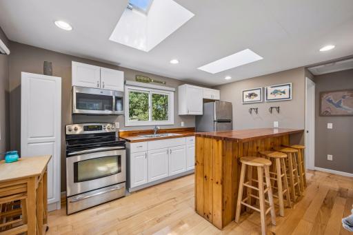 The kitchen has stainless steel appliances and a kitchen island / dining area for all to enjoy conversations.