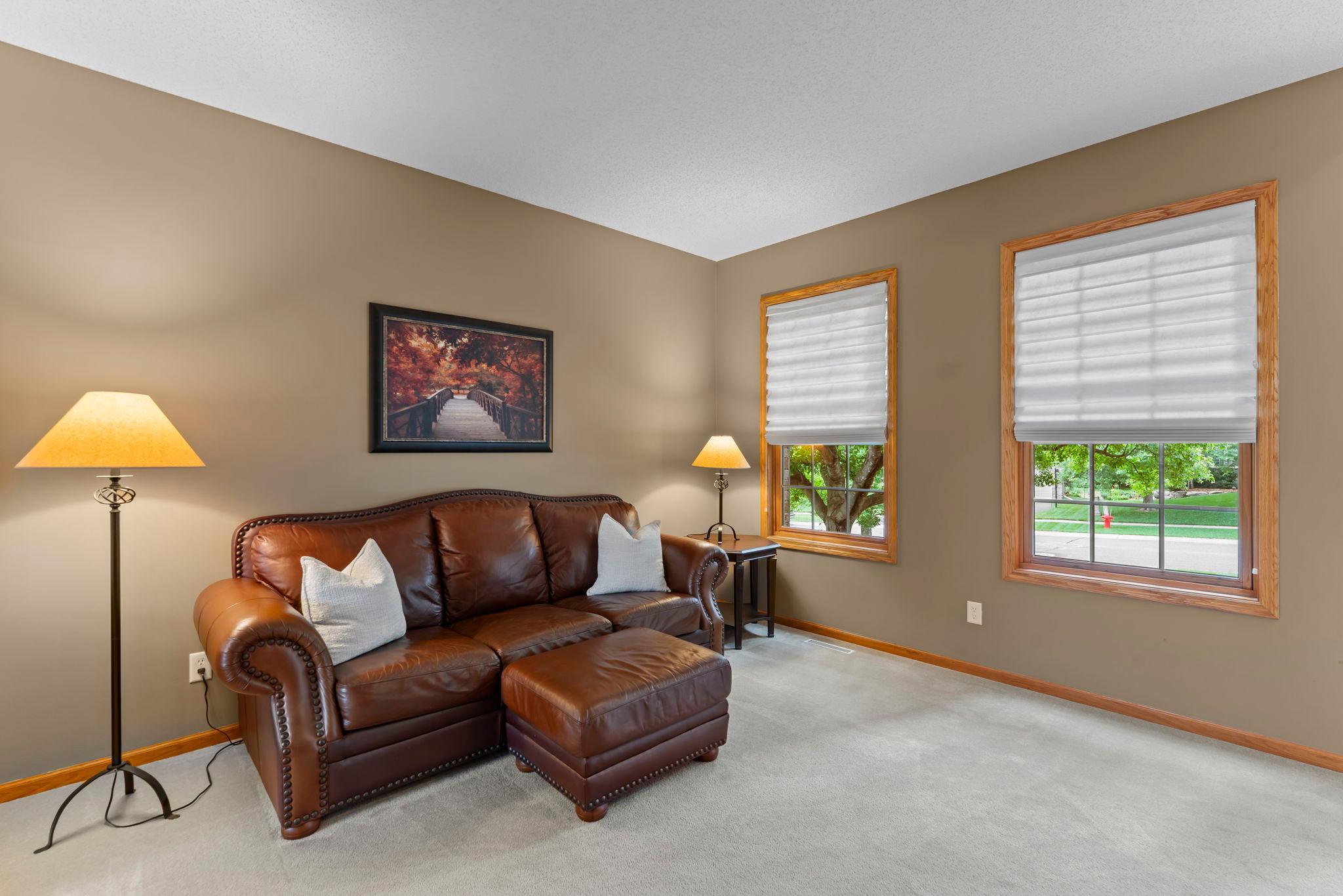 Bright living room with large windows overlooking the front yard