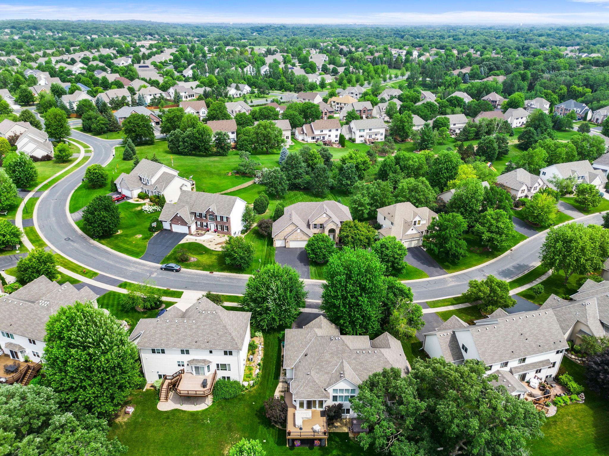A welcoming neighborhood setting with sidewalks and mature trees throughout