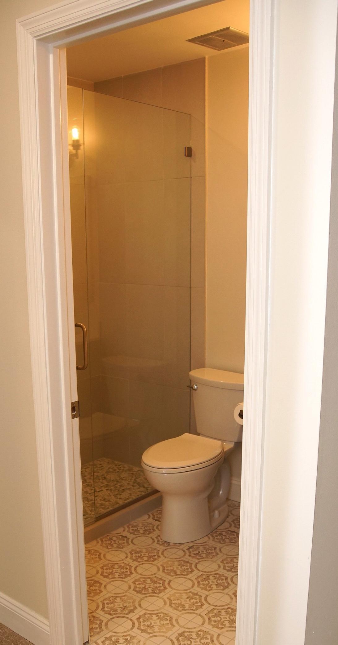 The Bedroom 1 en suite boasts a completely remodeled 3/4 bath, featuring new ceramic tiling and elegant glass shower doors.