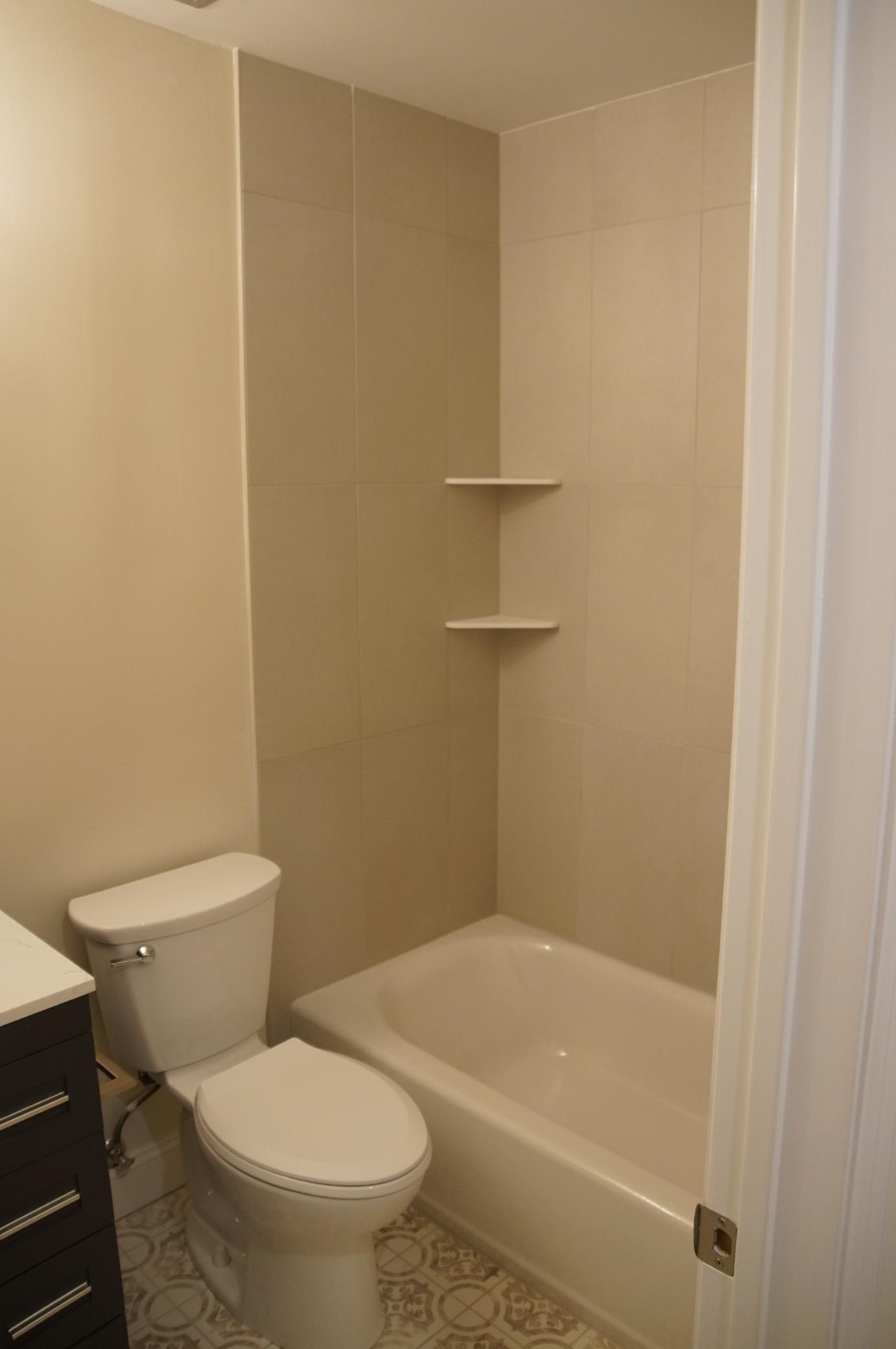 The primary upstairs bathroom has been updated with fresh paint, new tile, tub, toilet and a modern vanity.