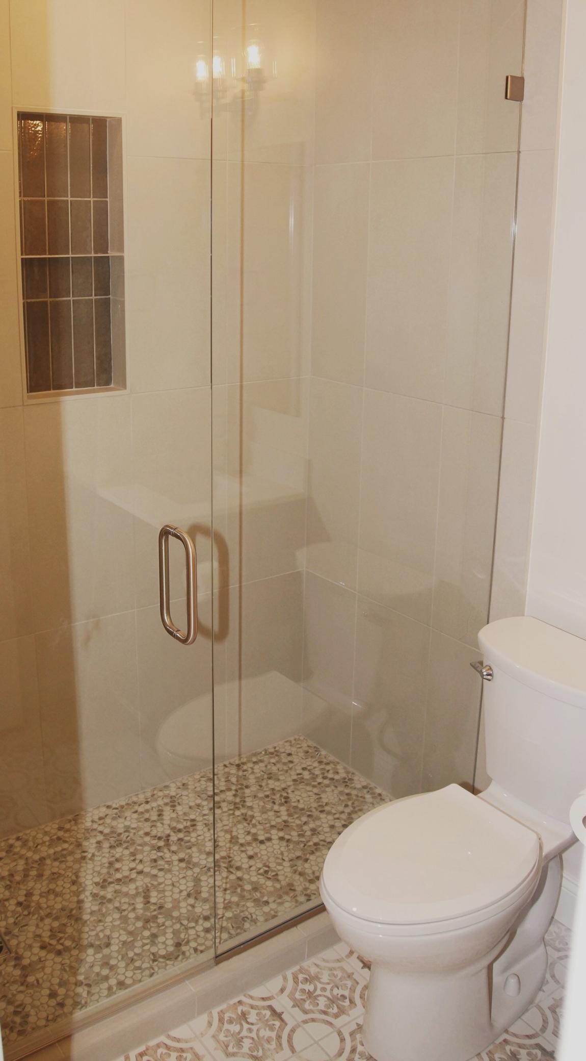 The Bedroom 1 en suite boasts a completely remodeled 3/4 bath, featuring new ceramic tiling and elegant glass shower doors.