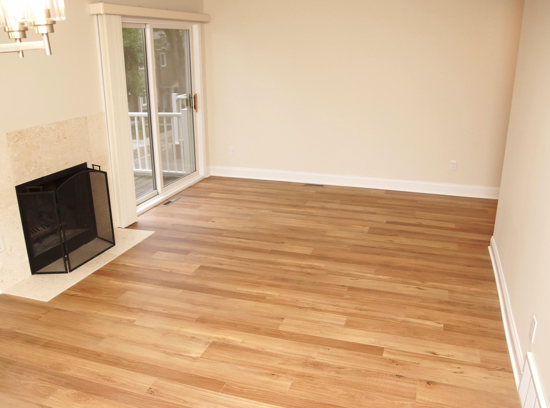 Formal Dining and Living Room area adjacent to the kitchen, featuring a wood-burning fireplace, fresh paint, brand-new flooring, and sliding glass doors that lead to a private deck.