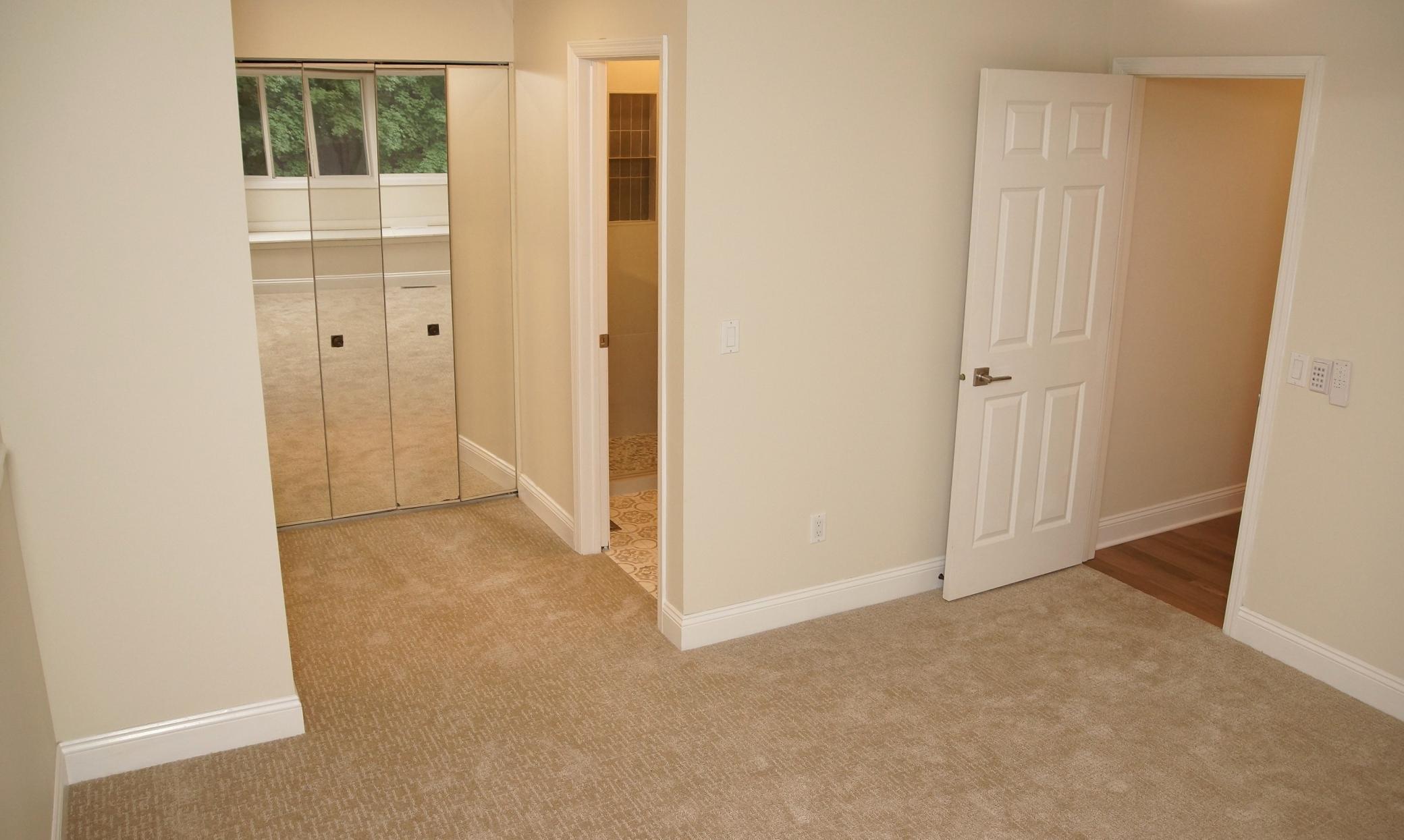 The main floor en suite features ample closet space and a mirrored dressing area adjacent to the 3/4 bath.