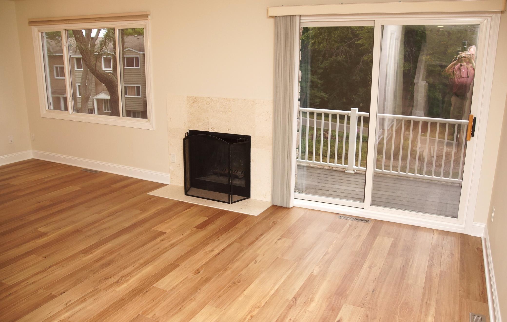 Formal Dining and Living Room area adjacent to the kitchen, featuring a wood-burning fireplace, fresh paint, brand-new flooring, and sliding glass doors that lead to a private deck.