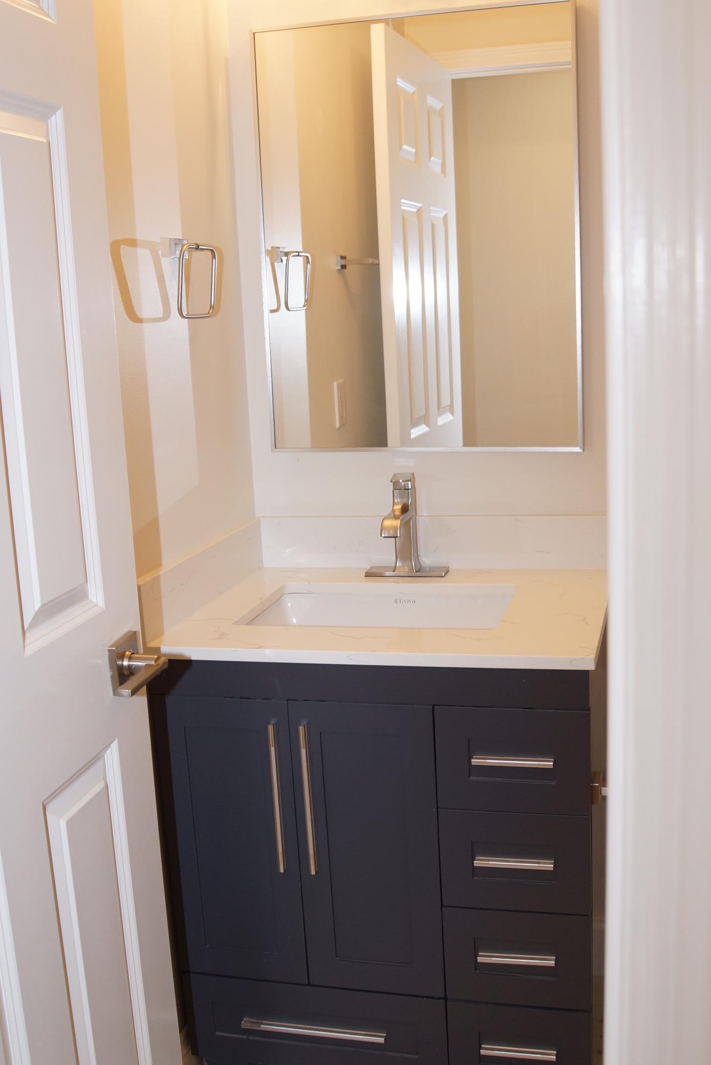 The primary upstairs bathroom has been updated with fresh paint, new tile, and a modern vanity.