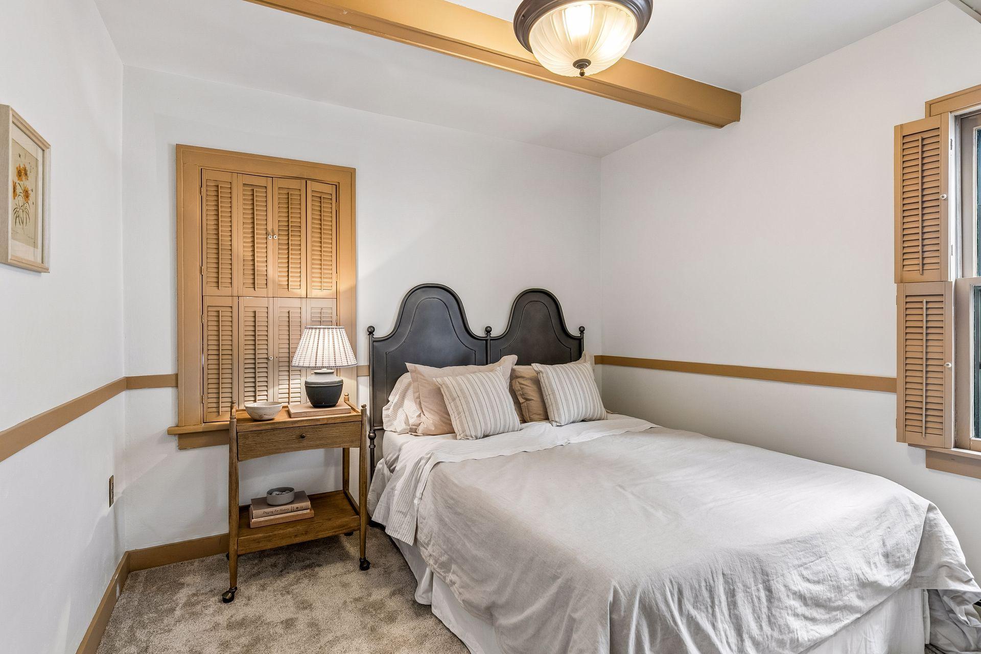 Bedroom 2 with beamed ceiling and shutters to den