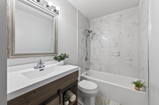 Updated bathroom with tiled tub and newer vanity