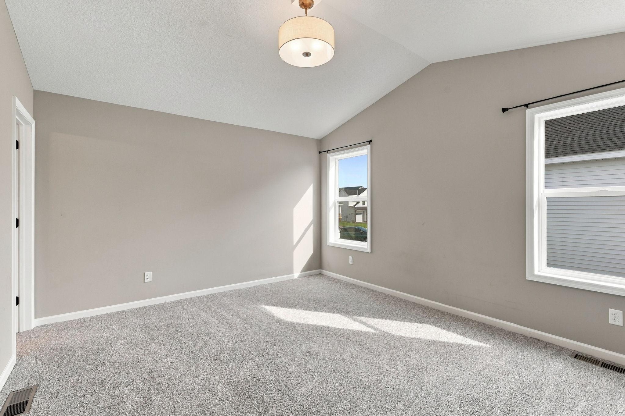 Primary bedroom with vaulted ceiling