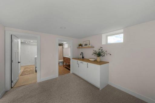 Spacious family room offers a versatile gathering area complete with a convenient wet bar—perfect for entertaining, movie nights, and relaxing.