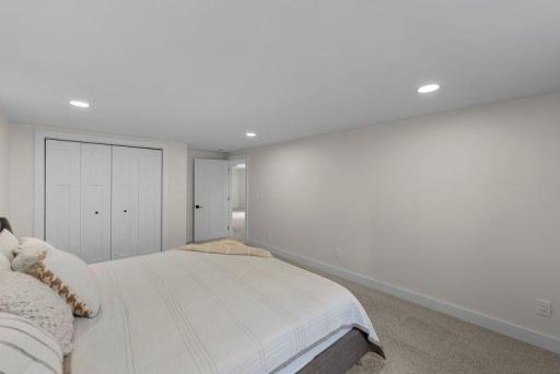 Bright and inviting bedroom with updated finishes, modern lighting, and a neutral color palette.