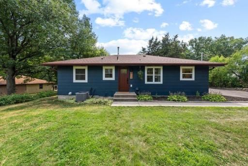 Generous front yard surrounded by mature landscaping provides a spacious, established setting with excellent curb appeal.