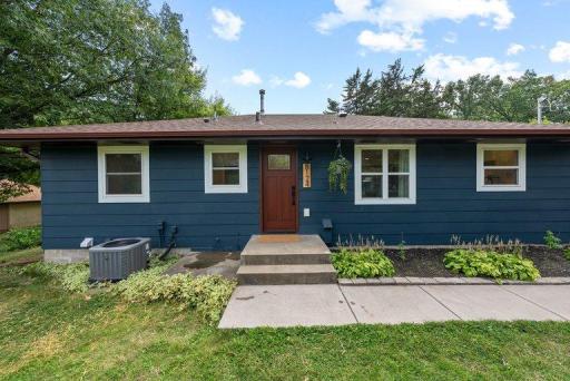 Beautifully updated exterior with professional landscaping, a new driveway, and mature trees creating a welcoming first impression.