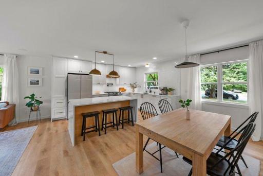 Beautifully remodeled kitchen featuring quartz countertops, custom cabinetry, contemporary finishes, updated lighting, and luxury vinyl plank flooring.