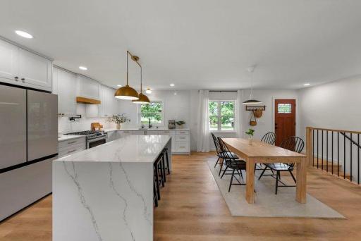Beautifully remodeled kitchen featuring quartz countertops, custom cabinetry, contemporary finishes, updated lighting, and luxury vinyl plank flooring.