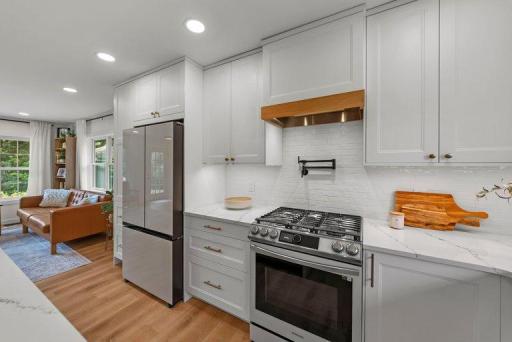 Samsung Bespoke white glass refrigerator and gas range provide a sleek, modern look while offering functionality for everyday cooking and entertaining.