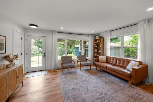 Bright and inviting living room features large windows that fill the space with natural light and a walkout to the spacious deck, creating a seamless connection between indoor and outdoor living.