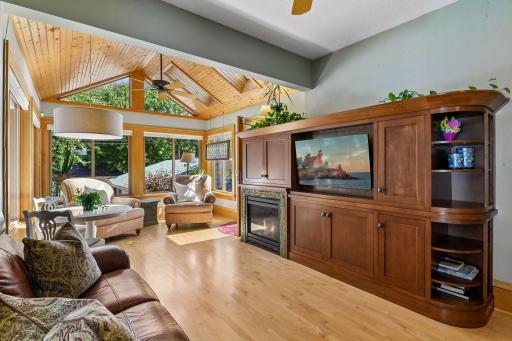 Stunning family room addition with vaulted ceilings featuring warm built-ins and another gas fireplace