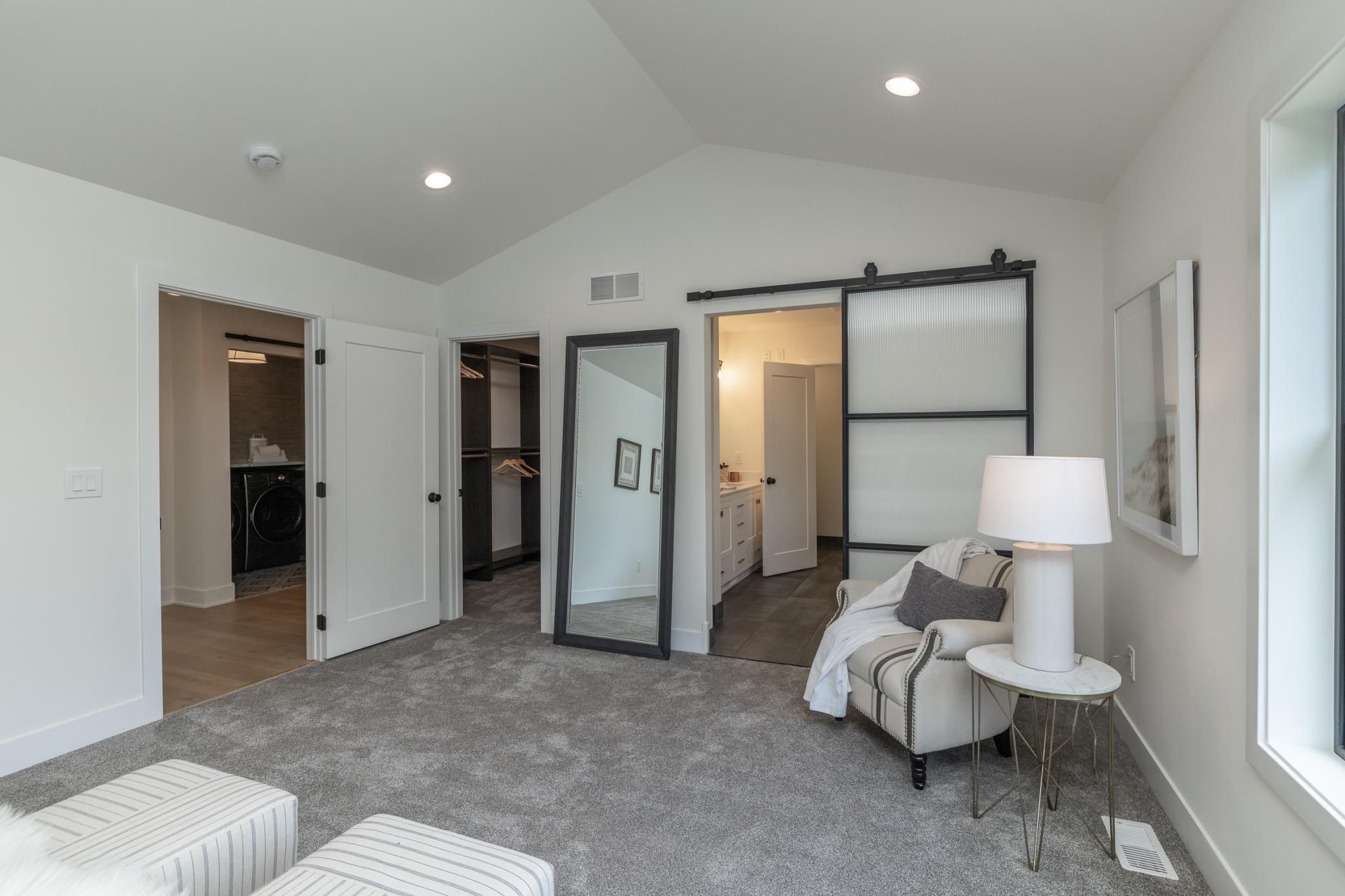 Primary bedroom sitting area leading to private bath and walk-in closet