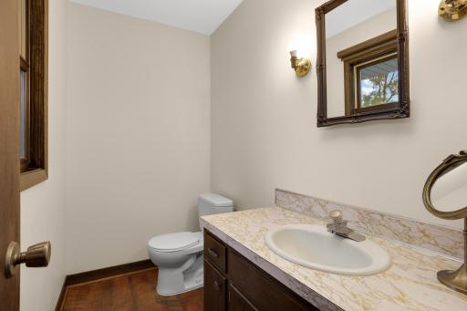 Spacious primary bedroom featuring beautiful wood floors, abundant natural light, and a private attached half bath.