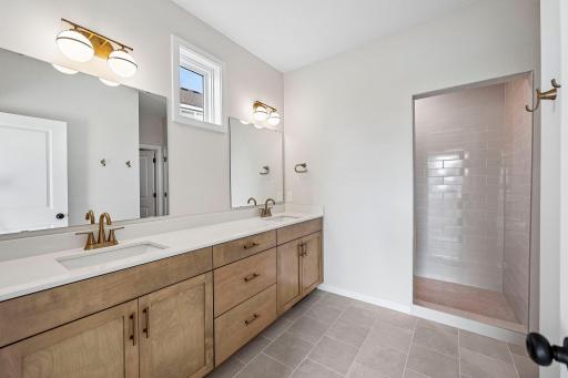 Large primary private bath with double sinks and walk-in shower.