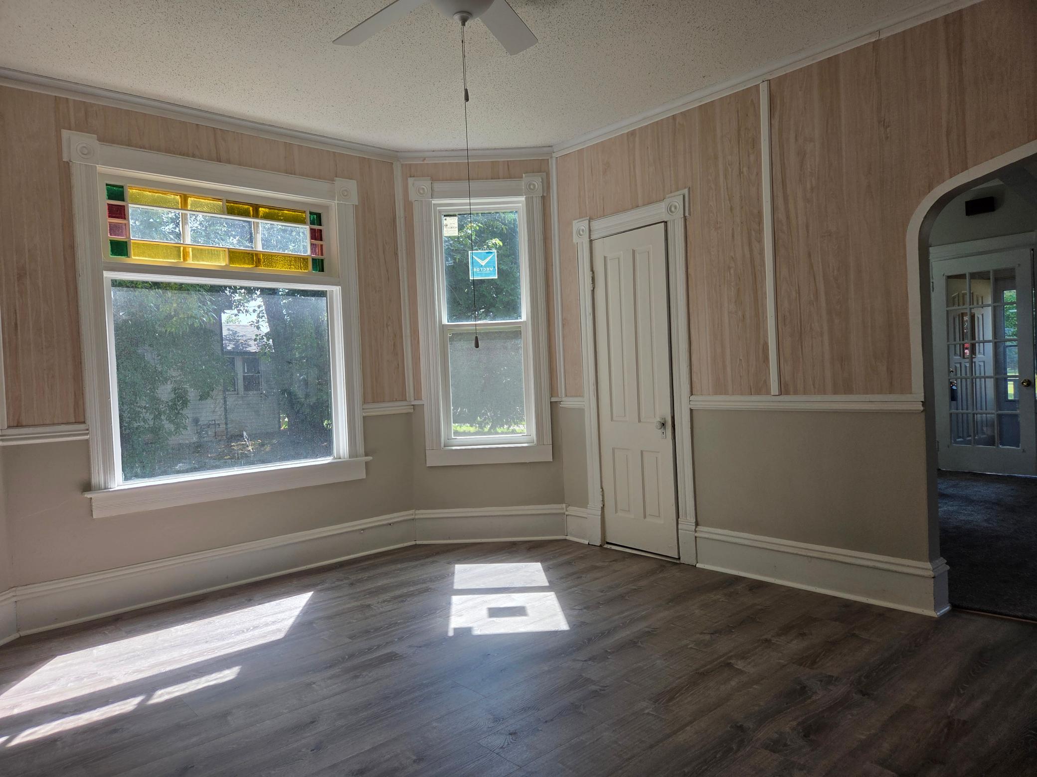 south facing bay window in formal dining room with stain glass window upper