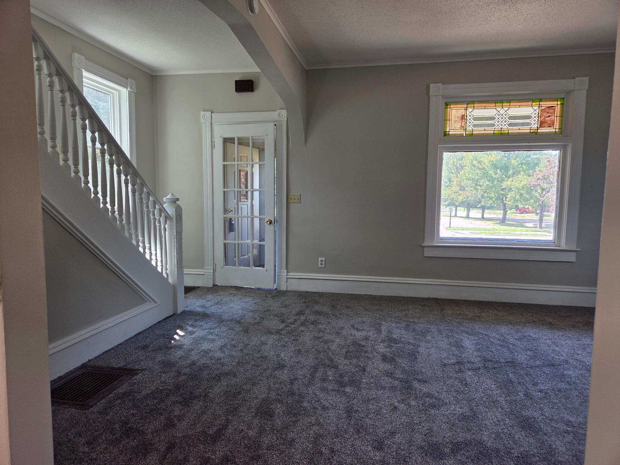 living room with stair case and front door