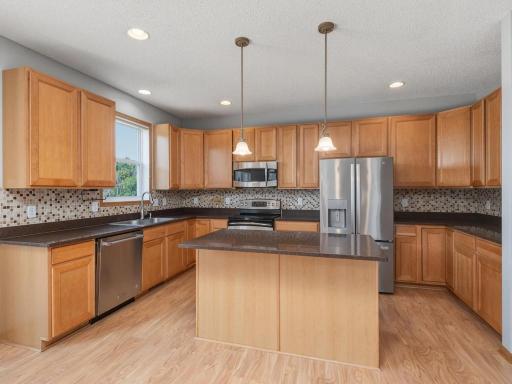 A kitchen made for entertaining! Abundant storage & countertop space, finished with quartz countertops, tile backsplash & stainless steel appliances.