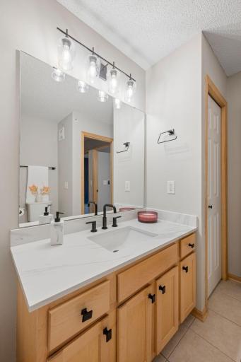 Updated bathroom countertop, oversized mirror, and modern lighting create a clean, refreshed look.