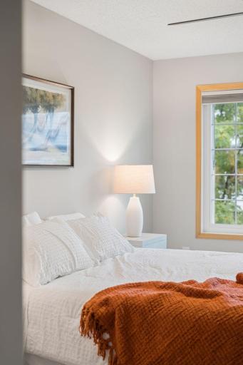 Bright primary bedroom filled with natural light from the large window.