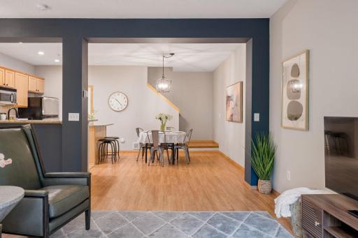 Open-concept living and dining spaces accented by modern dark feature walls and warm flooring.