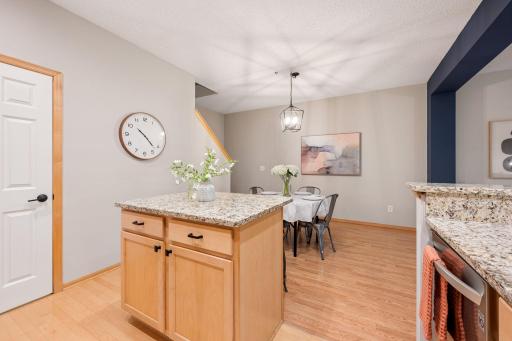 Kitchen island provides additional workspace and storage while opening to the dining area.