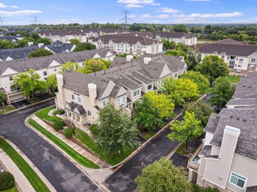 Aerial view of the well-maintained townhome community, showcasing mature trees, landscaped common areas, and an established neighborhood setting.
