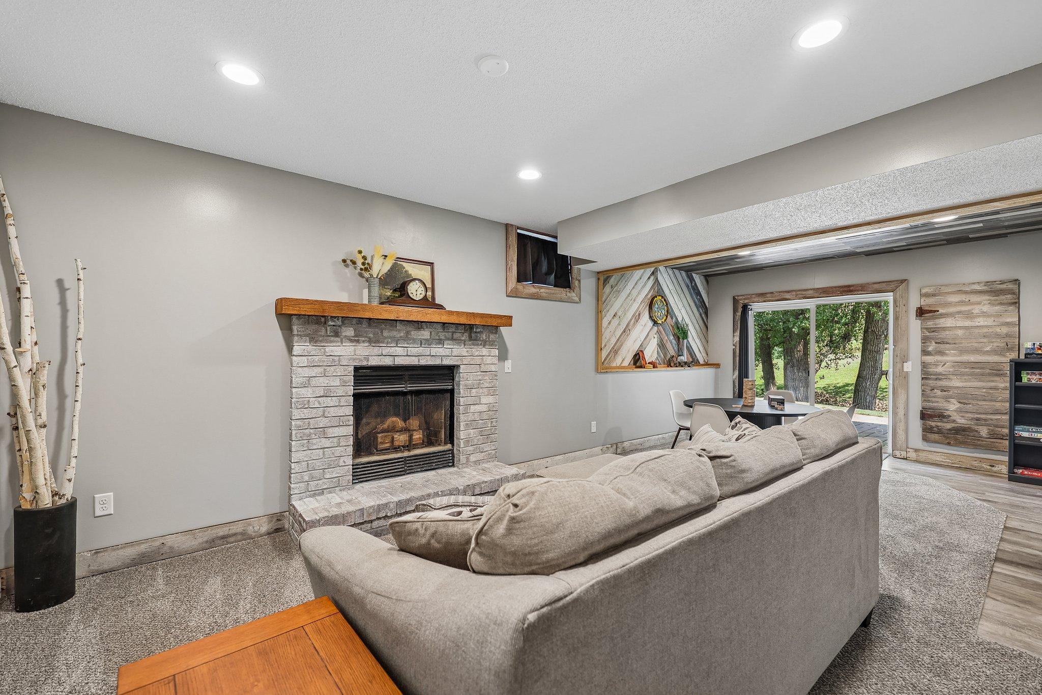 Cozy up in the lower level with a wood burning fireplace with beautiful brick surround.