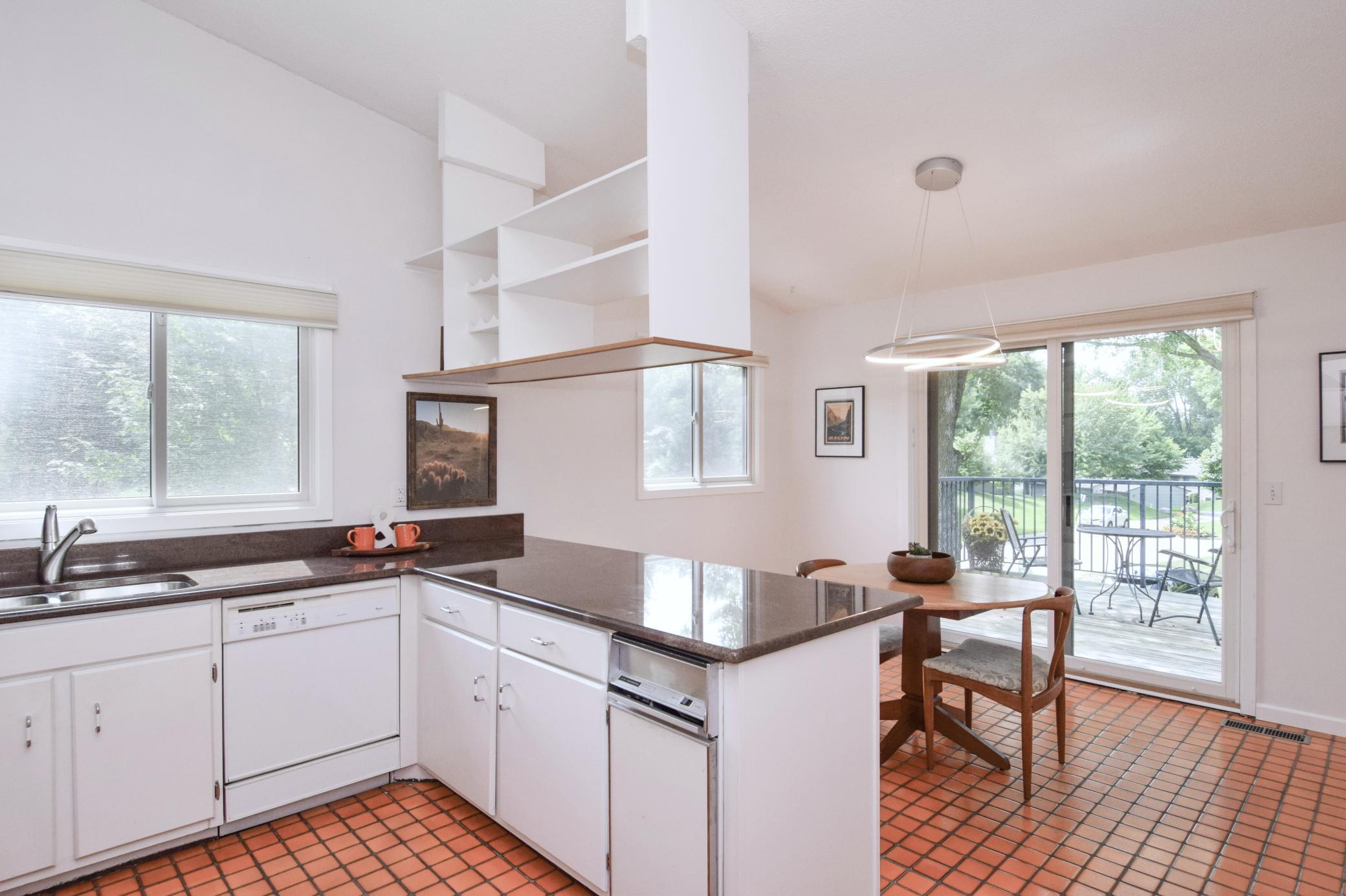 Bright and cheerful kitchen and dining area with an inviting open layout that flows seamlessly onto a large deck!