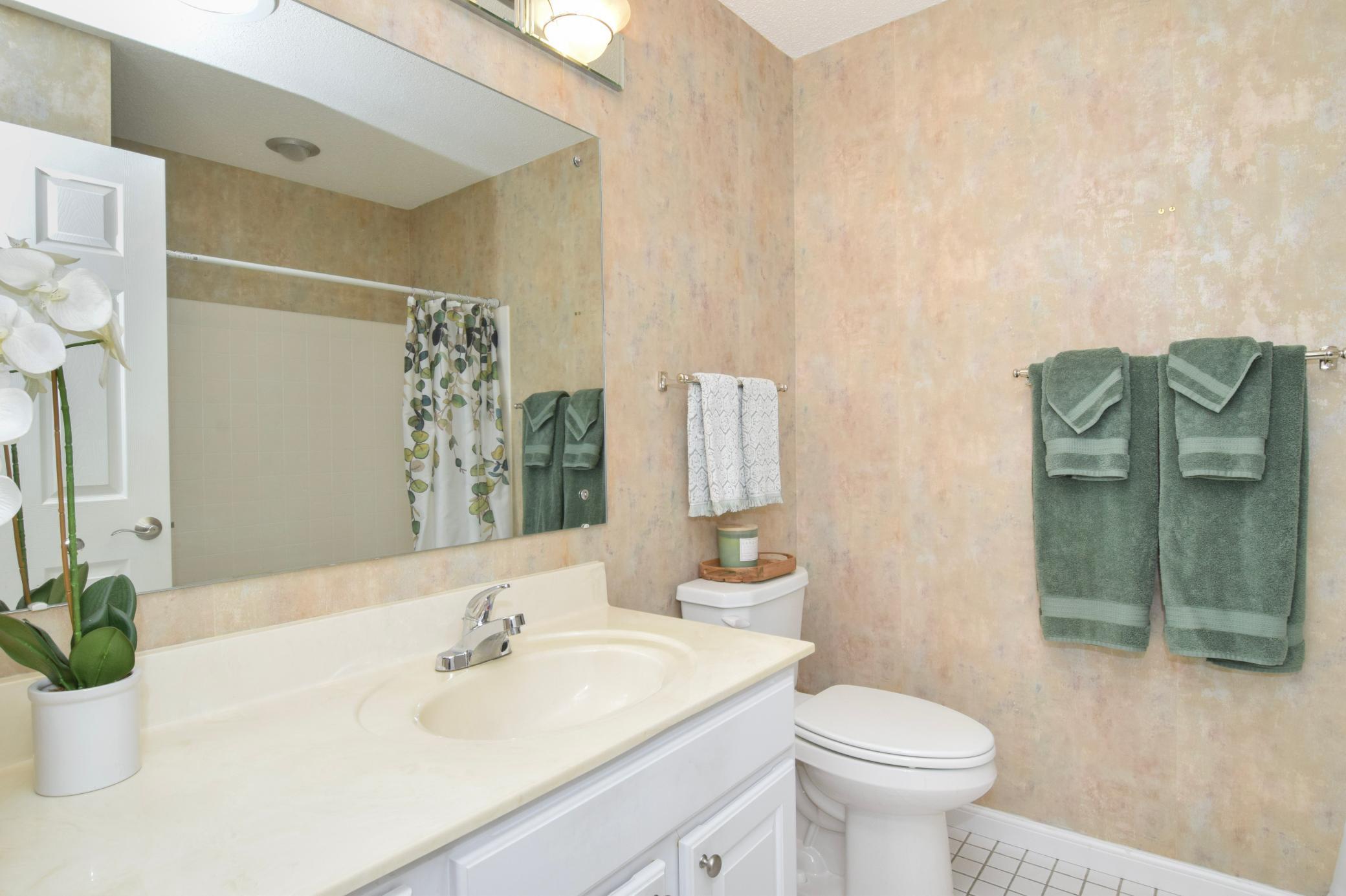The main level bathroom with tiled floors & a sun tube keeps the room bright.