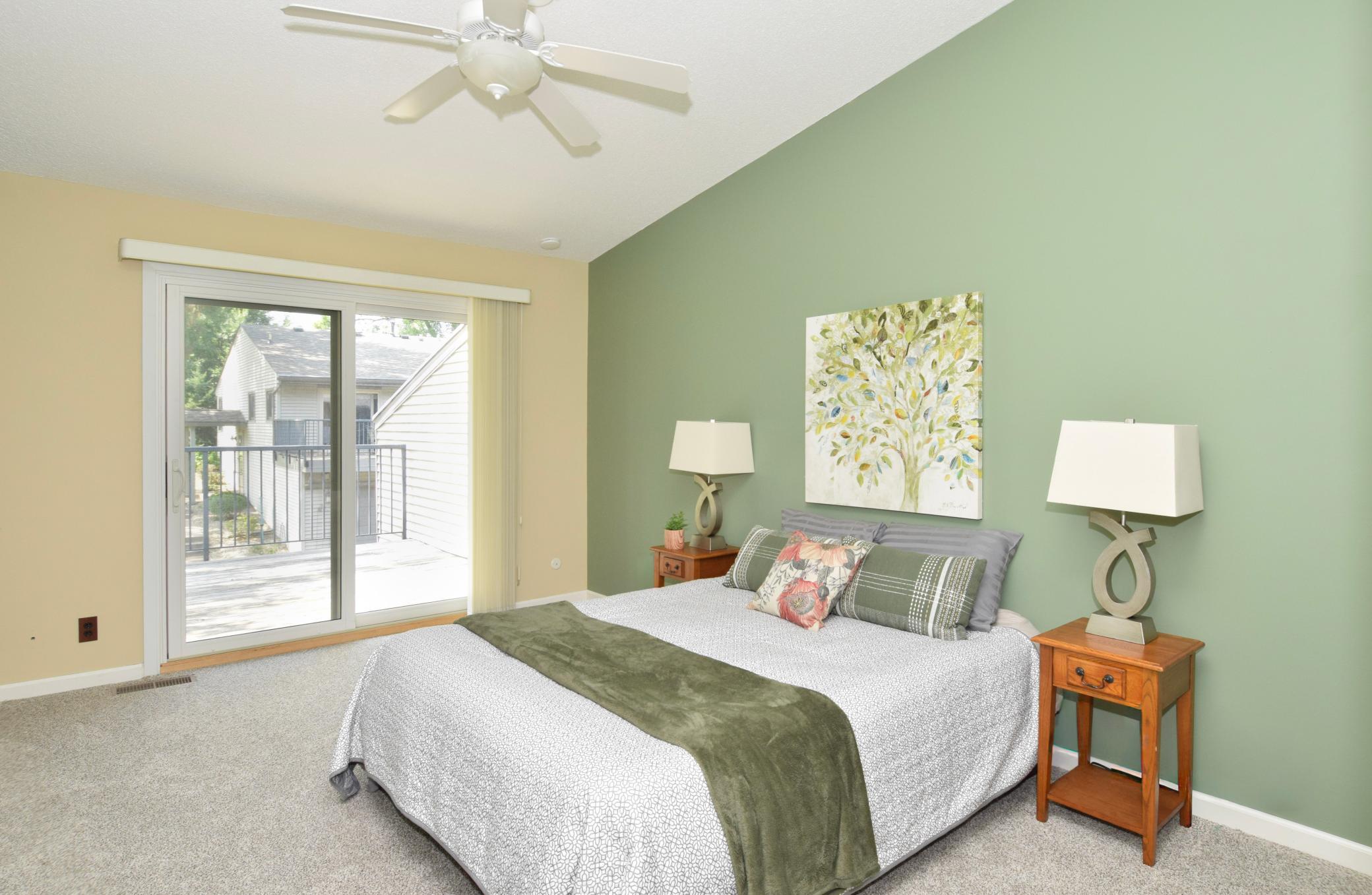 The bedroom features a vaulted ceiling, new carpet, ceiling fan, access to the deck & a walk-in closet!