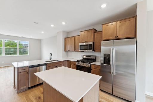 Gather round the center island that provides additional seating, surface space and storage. Similar home shown, color and options can vary.