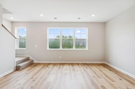The spacious family room is filled with natural light. Similar home shown. Color and finish can vary.