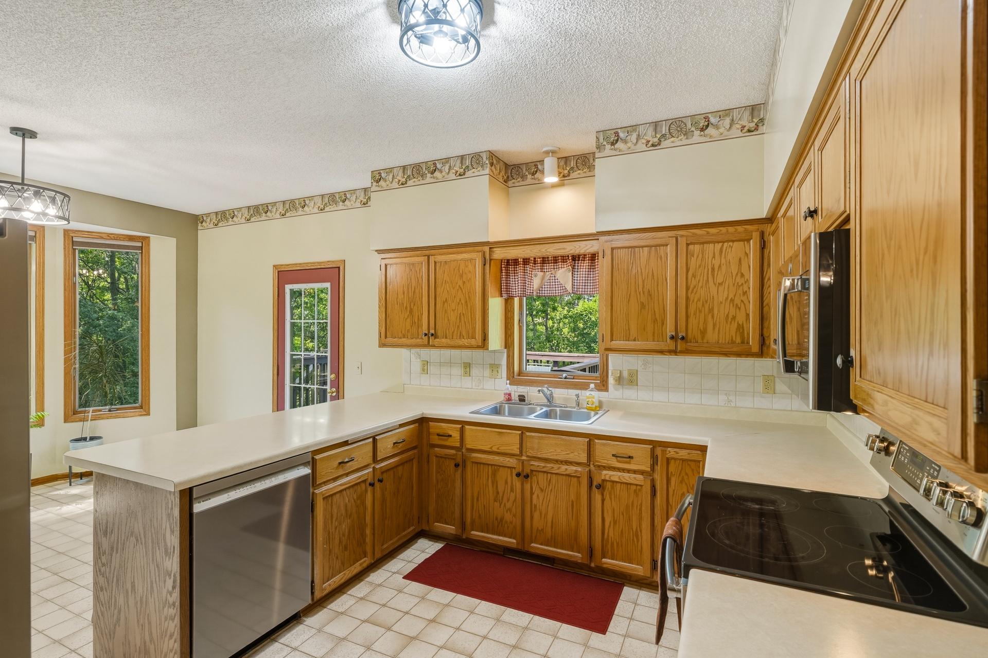 The Kitchen Features Stainless Steel Appliances and a Window Overlooking the Deck